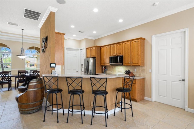 1456 SW Del Rio Blvd, Port Saint Lucie, FL 34953 - kitchen featuring appliances with stainless steel finishes, a breakfast bar area, backsplash, baseboards, and light tile patterned floors