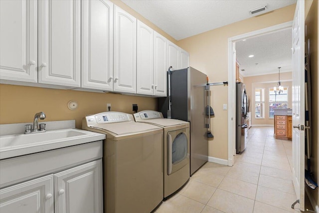 1456 SW Del Rio Blvd, Port Saint Lucie, FL 34953 - laundry area with light tile patterned flooring, cabinet space, separate washer and dryer, a textured ceiling, and baseboards