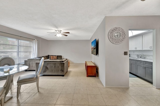 600 Pine Dr Unit 104, Pompano Beach, FL 33060 - living area with a ceiling fan, a textured ceiling, light tile patterned flooring, and baseboards