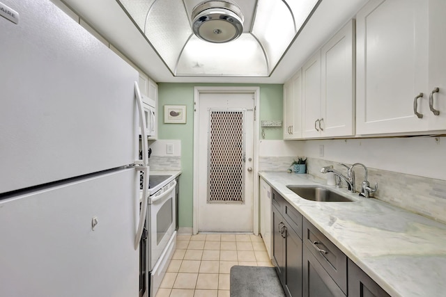 600 Pine Dr Unit 104, Pompano Beach, FL 33060 - kitchen featuring white appliances, a sink, light tile patterned floors, light stone counters, and white cabinetry