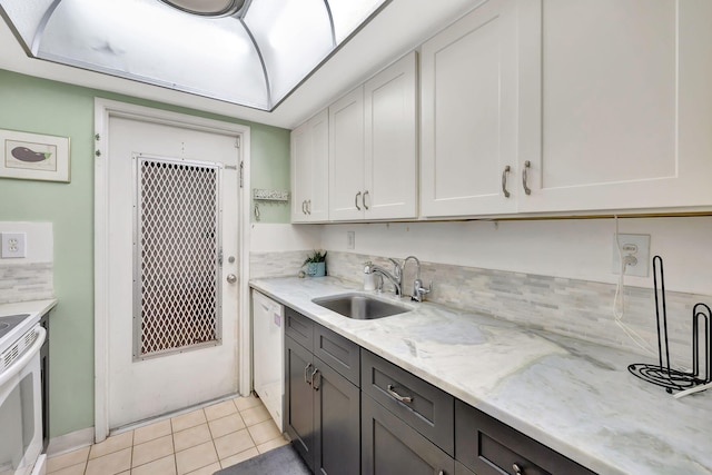 600 Pine Dr Unit 104, Pompano Beach, FL 33060 - kitchen featuring a sink, white appliances, white cabinets, light stone counters, and light tile patterned floors