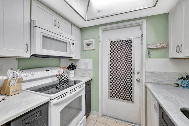 600 Pine Dr Unit 104, Pompano Beach, FL 33060 - kitchen with white appliances, white cabinets, tasteful backsplash, and light tile patterned floors