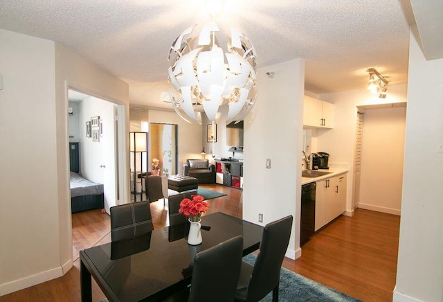 160 Yacht Club Way Unit 309, Hypoluxo, FL 33462 - dining room featuring a chandelier, wood finished floors, a textured ceiling, and baseboards
