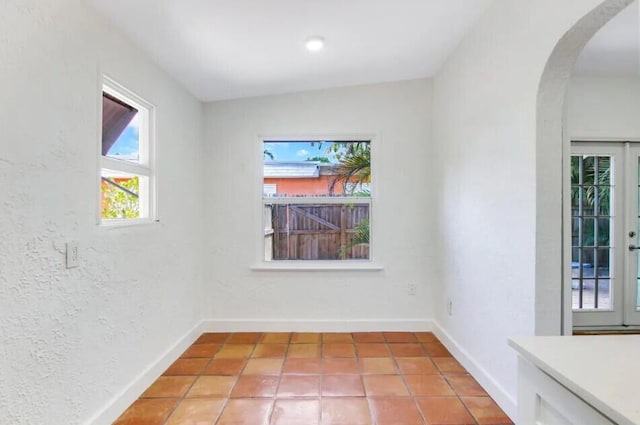 616 Claremore Dr Unit 1, 2, 3, West Palm Beach, FL 33401 - spare room with arched walkways, baseboards, light tile patterned floors, and a textured wall