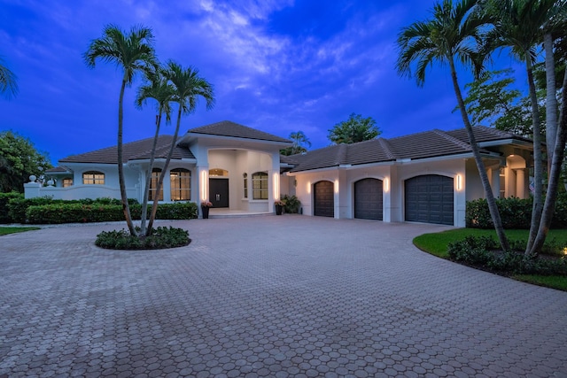 8246 Man O War Rd, Palm Beach Gardens, FL 33418 - mediterranean / spanish-style house featuring curved driveway, a garage, stucco siding, and a tiled roof