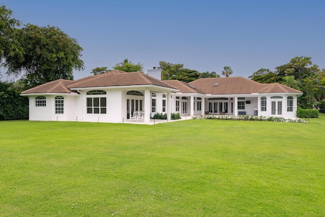 8246 Man O War Rd, Palm Beach Gardens, FL 33418 - rear view of house featuring a chimney, a yard, a tile roof, and a patio