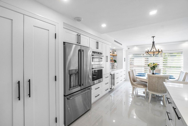 875 E Camino Real Unit 3E, Boca Raton, FL 33432 - kitchen featuring stainless steel appliances, a chandelier, white cabinets, light marble finish flooring, and light countertops
