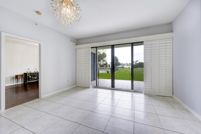 370 Golfview Rd Unit 103, North Palm Beach, FL 33408 - unfurnished room with light tile patterned floors, a chandelier, and a smoke detector