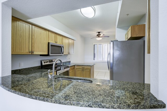 370 Golfview Rd Unit 103, North Palm Beach, FL 33408 - kitchen with appliances with stainless steel finishes, ceiling fan, a peninsula, and light tile patterned floors