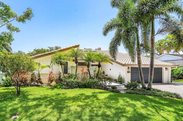 2626 NW 42nd St, Boca Raton, FL 33434 - mediterranean / spanish house featuring an attached garage, a front yard, stucco siding, driveway, and a tile roof