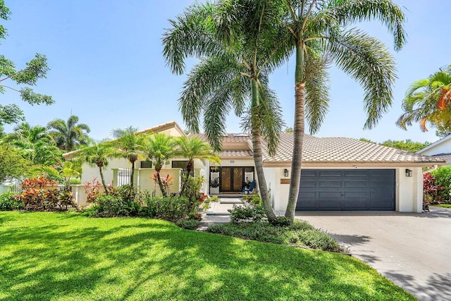 2626 NW 42nd St, Boca Raton, FL 33434 - mediterranean / spanish-style home with a garage, stucco siding, a front yard, and driveway