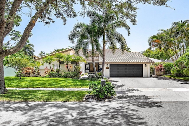 2626 NW 42nd St, Boca Raton, FL 33434 - view of front of property with a garage, driveway, stucco siding, and a front yard