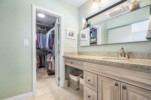 2626 NW 42nd St, Boca Raton, FL 33434 - bathroom with vanity, a walk in closet, baseboards, and tile patterned flooring