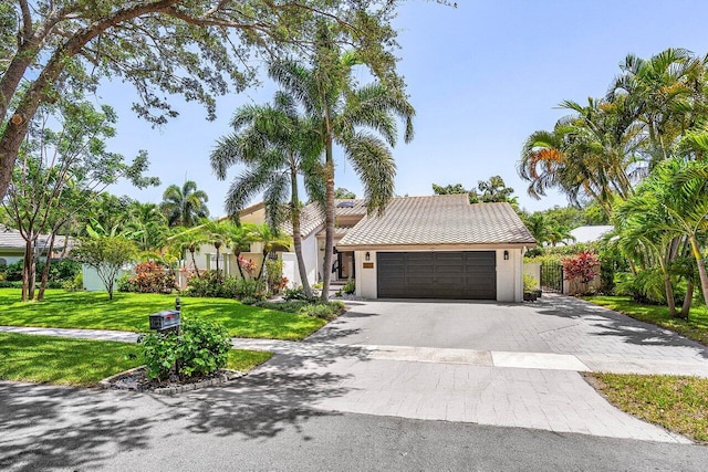 2626 NW 42nd St, Boca Raton, FL 33434 - view of front of property with asphalt driveway, a garage, stucco siding, and a tiled roof