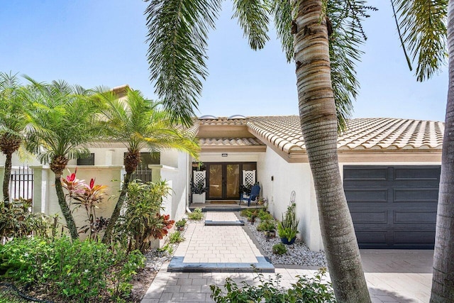 2626 NW 42nd St, Boca Raton, FL 33434 - view of front of property featuring stucco siding, french doors, a garage, and a tiled roof