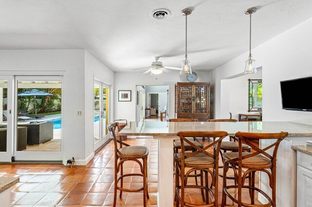 310 NW 18th St, Delray Beach, FL 33444 - kitchen with healthy amount of natural light, a ceiling fan, a kitchen breakfast bar, and pendant lighting