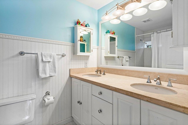 310 NW 18th St, Delray Beach, FL 33444 - full bathroom featuring toilet, wainscoting, double vanity, and a shower with curtain