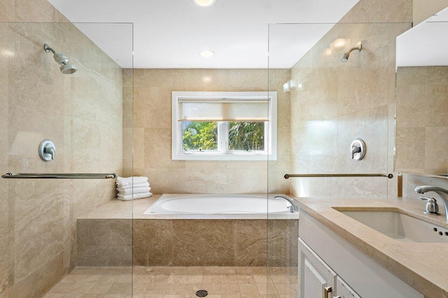 310 NW 18th St, Delray Beach, FL 33444 - bathroom featuring tile walls, tiled shower, vanity, a garden tub, and tile patterned flooring