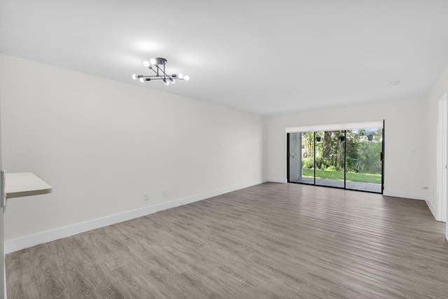 2517 S 17th St Unit 102, Fort Pierce, FL 34982 - unfurnished room featuring a chandelier, wood finished floors, and baseboards