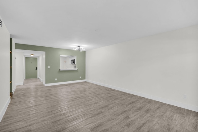 2517 S 17th St Unit 102, Fort Pierce, FL 34982 - spare room featuring wood finished floors, a chandelier, and baseboards