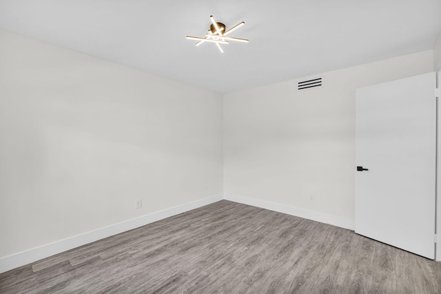 2517 S 17th St Unit 102, Fort Pierce, FL 34982 - spare room with wood finished floors, a chandelier, and baseboards
