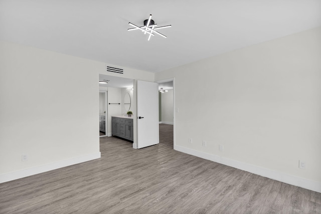 2517 S 17th St Unit 102, Fort Pierce, FL 34982 - unfurnished living room featuring wood finished floors, a chandelier, and baseboards