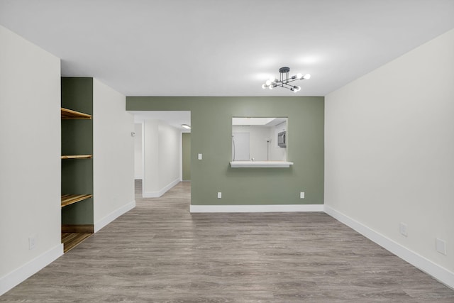 2517 S 17th St Unit 102, Fort Pierce, FL 34982 - empty room featuring a chandelier, wood finished floors, and baseboards