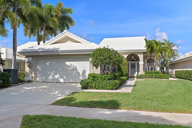 1415 Bear Island Dr, West Palm Beach, FL 33409 - view of front of house featuring a garage, central air condition unit, concrete driveway, a front yard, and stucco siding
