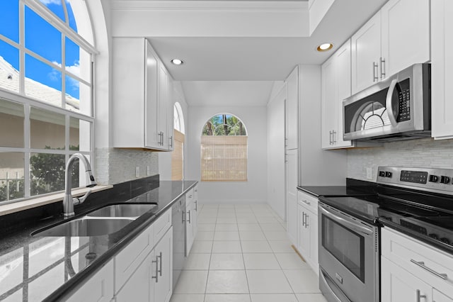 1415 Bear Island Dr, West Palm Beach, FL 33409 - kitchen with appliances with stainless steel finishes, a sink, recessed lighting, light tile patterned floors, and dark stone counters