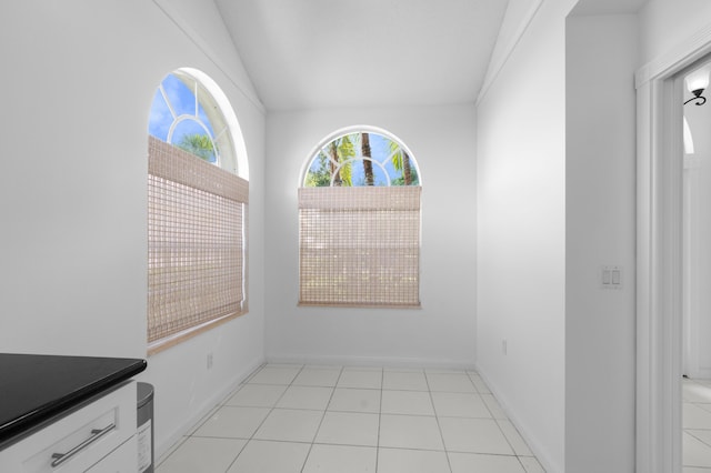 1415 Bear Island Dr, West Palm Beach, FL 33409 - unfurnished dining area with vaulted ceiling, light tile patterned flooring, and baseboards