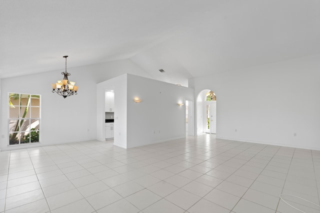 1415 Bear Island Dr, West Palm Beach, FL 33409 - unfurnished living room featuring a chandelier, arched walkways, vaulted ceiling, and light tile patterned floors