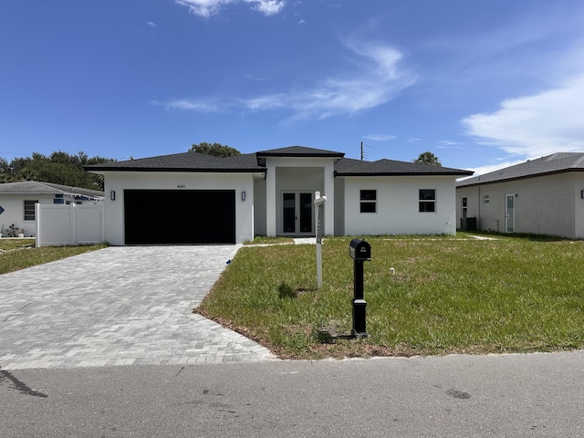 4641 Northview Dr, Jupiter, FL 33458 - prairie-style home with stucco siding, an attached garage, and decorative driveway