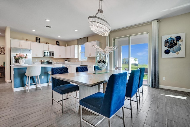 12623 NW Copper Creek Dr, Port Saint Lucie, FL 34987 - dining room with a chandelier, baseboards, wood finish floors, and recessed lighting