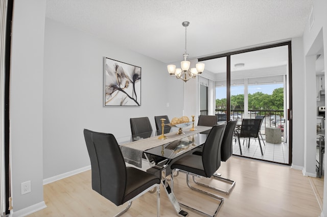 6815 Willow Wood Dr Unit 4022, Boca Raton, FL 33434 - dining room featuring a chandelier, light wood finished floors, a textured ceiling, and baseboards