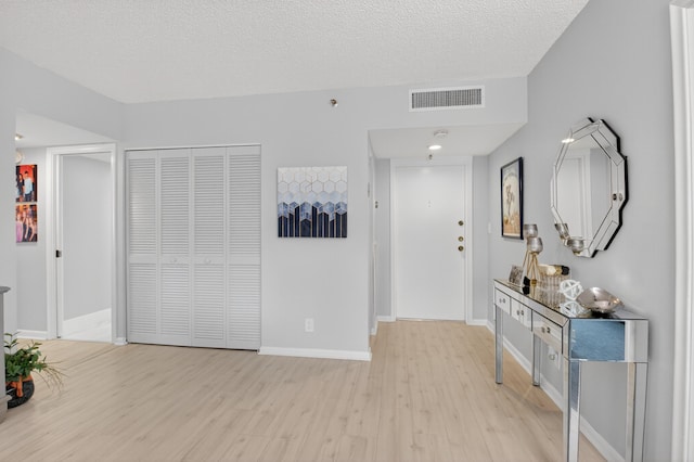 6815 Willow Wood Dr Unit 4022, Boca Raton, FL 33434 - entryway featuring light wood-type flooring, baseboards, and a textured ceiling