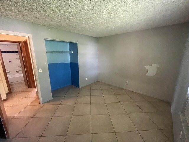 2955 SW Varsity Ln, Port Saint Lucie, FL 34953 - unfurnished bedroom featuring a textured ceiling, tile patterned flooring, and a closet