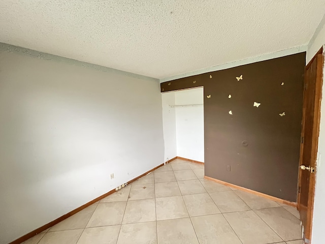 2955 SW Varsity Ln, Port Saint Lucie, FL 34953 - unfurnished bedroom with a textured ceiling, light tile patterned floors, and baseboards