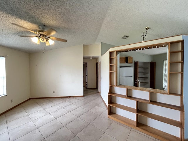 2955 SW Varsity Ln, Port Saint Lucie, FL 34953 - empty room with ceiling fan, light tile patterned flooring, baseboards, a sink, and a textured ceiling