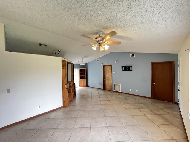 2955 SW Varsity Ln, Port Saint Lucie, FL 34953 - spare room with ceiling fan, vaulted ceiling, a textured ceiling, baseboards, and light tile patterned floors