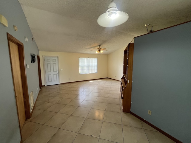 2955 SW Varsity Ln, Port Saint Lucie, FL 34953 - spare room with ceiling fan, a textured ceiling, light tile patterned floors, and baseboards