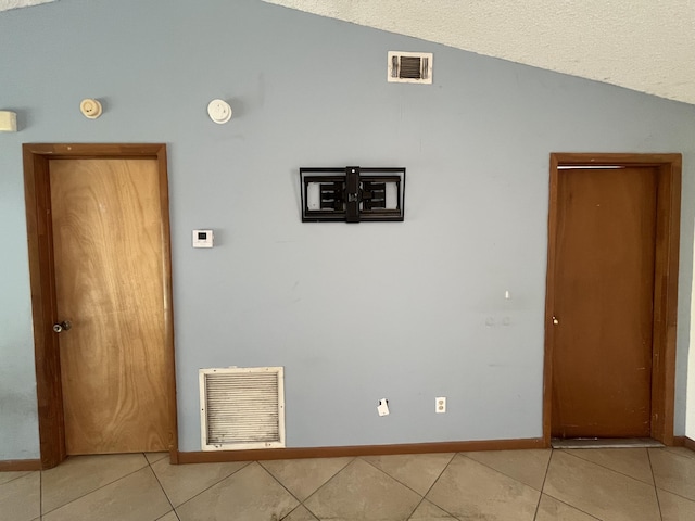 2955 SW Varsity Ln, Port Saint Lucie, FL 34953 - empty room with vaulted ceiling, light tile patterned floors, and baseboards