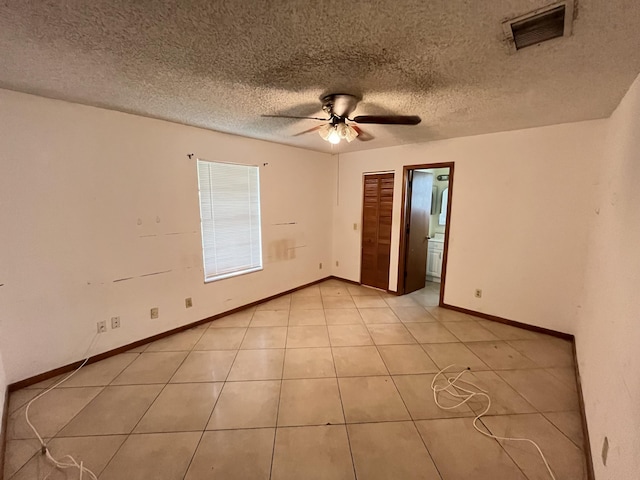 2955 SW Varsity Ln, Port Saint Lucie, FL 34953 - empty room featuring a ceiling fan, a textured ceiling, baseboards, and light tile patterned floors