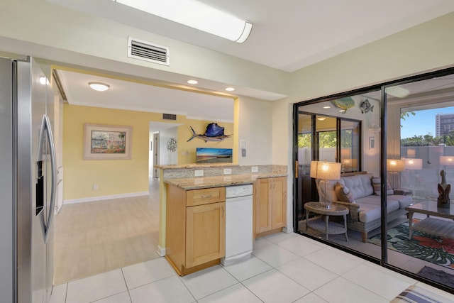 3209 S Lakeview Cir Unit 8-101, Hutchinson Island, FL 34949 - kitchen with stainless steel fridge with ice dispenser, light brown cabinets, a peninsula, open floor plan, and light stone counters