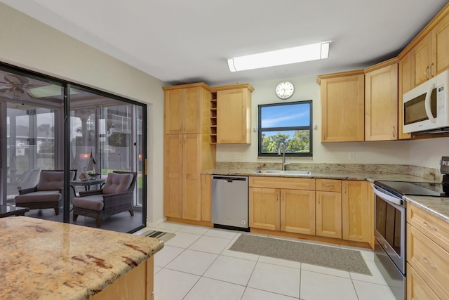 3209 S Lakeview Cir Unit 8-101, Hutchinson Island, FL 34949 - kitchen with stainless steel appliances, light tile patterned floors, light stone counters, and light brown cabinets