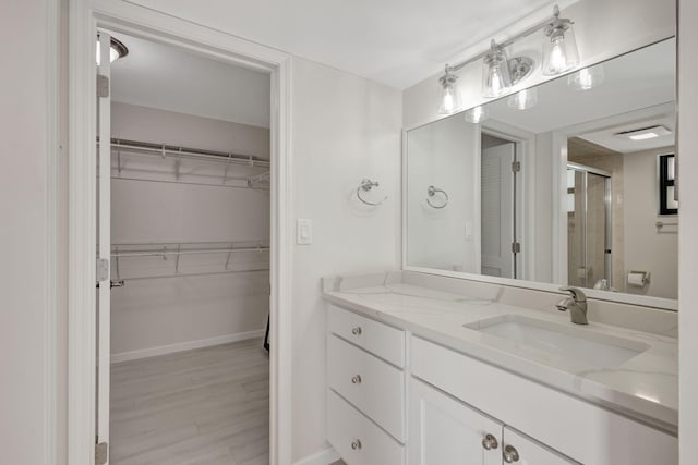 3209 S Lakeview Cir Unit 8-101, Hutchinson Island, FL 34949 - bathroom with a shower stall, vanity, a spacious closet, and wood finished floors