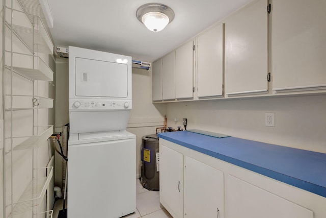 3209 S Lakeview Cir Unit 8-101, Hutchinson Island, FL 34949 - laundry area featuring stacked washer and clothes dryer, light tile patterned flooring, and cabinet space