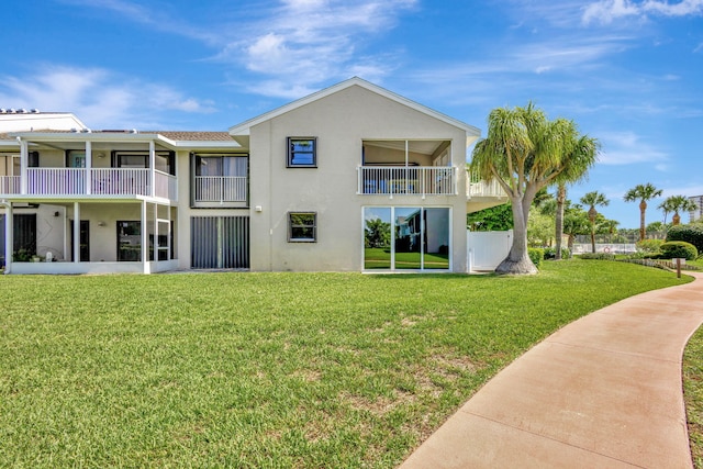 3209 S Lakeview Cir Unit 8-101, Hutchinson Island, FL 34949 - back of house with stucco siding, a lawn, and a balcony