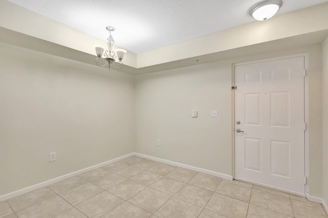 3693 NW Adriatic Ln, Jensen Beach, FL 34957 - unfurnished room with light tile patterned flooring, a chandelier, and baseboards