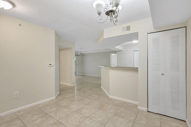 3693 NW Adriatic Ln, Jensen Beach, FL 34957 - empty room featuring a chandelier, light tile patterned flooring, and baseboards