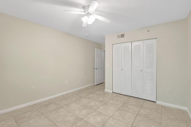 3693 NW Adriatic Ln, Jensen Beach, FL 34957 - unfurnished bedroom with a closet, baseboards, light tile patterned flooring, and a ceiling fan